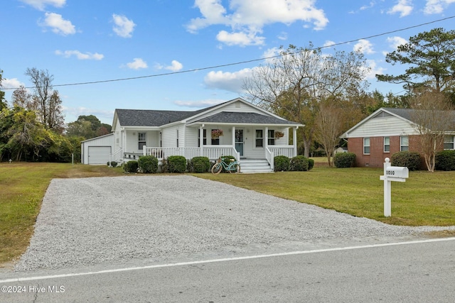 view of front of house with a porch, a front lawn, an outdoor structure, and a garage