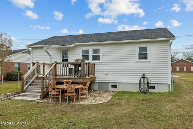 back of property featuring a wooden deck and a lawn