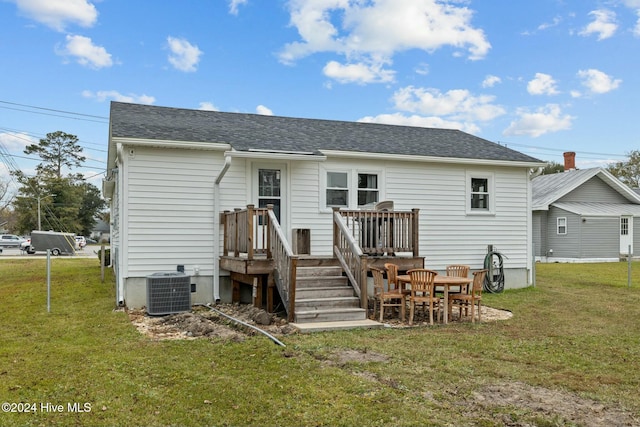 rear view of property featuring central AC, a yard, and a wooden deck