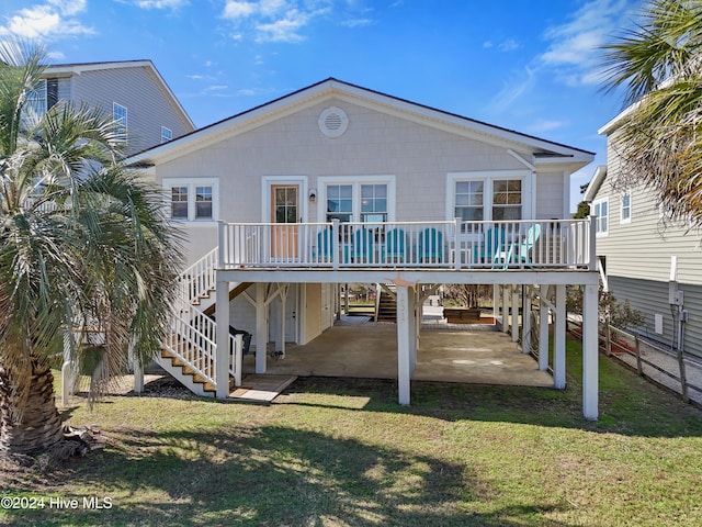 rear view of house featuring a deck, a lawn, and a patio