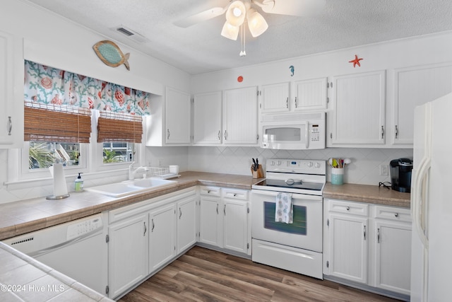 kitchen featuring white cabinets, dark wood-type flooring, sink, and white appliances