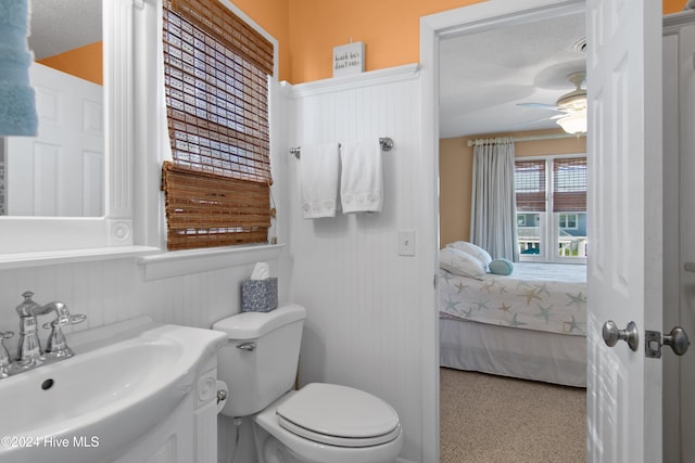 bathroom with toilet, vanity, a textured ceiling, and ceiling fan