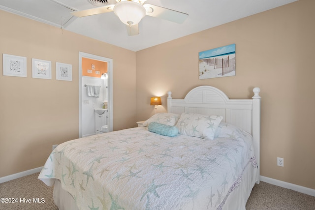 carpeted bedroom with ensuite bath and ceiling fan