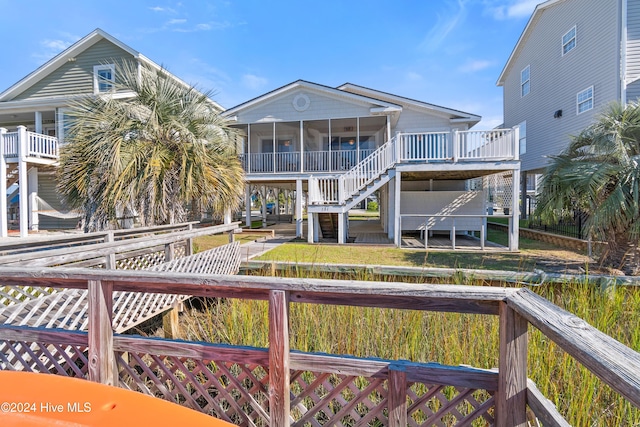 back of property with a sunroom and a wooden deck