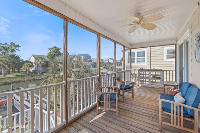 sunroom with a water view and ceiling fan