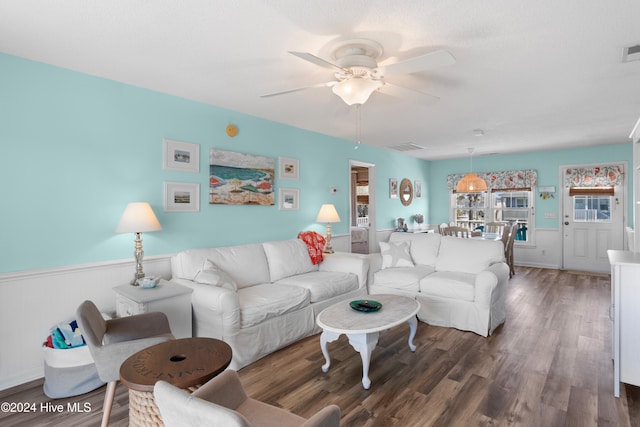 living room featuring dark wood-type flooring and ceiling fan