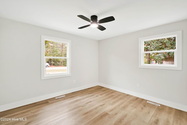 spare room featuring plenty of natural light, ceiling fan, and light wood-type flooring