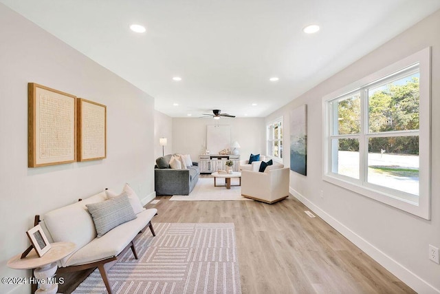 living room featuring ceiling fan and light hardwood / wood-style floors