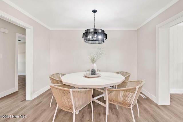 dining area featuring a chandelier, light hardwood / wood-style floors, and ornamental molding