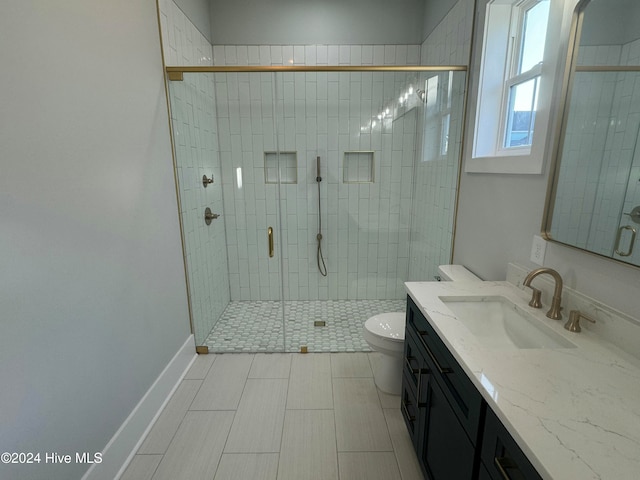 bathroom with a shower with shower door, vanity, and toilet