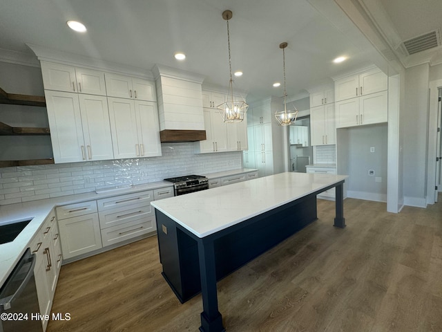 kitchen with white cabinetry, hanging light fixtures, a kitchen island, dark hardwood / wood-style flooring, and decorative backsplash