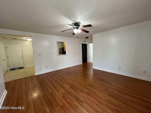 empty room featuring hardwood / wood-style floors, a textured ceiling, and ceiling fan