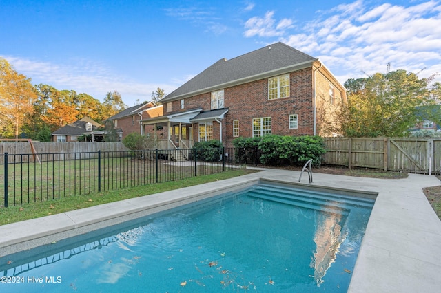 view of pool with a lawn and a patio