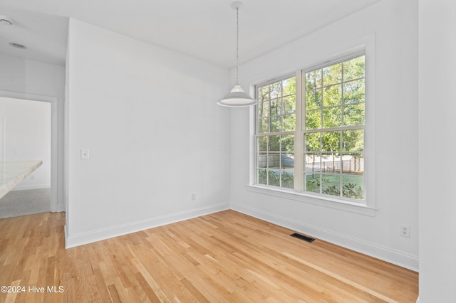 unfurnished room featuring hardwood / wood-style flooring and a wealth of natural light