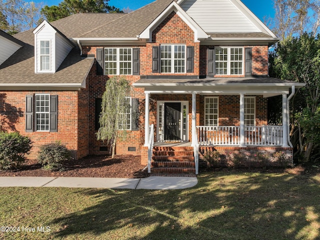 view of front facade featuring covered porch and a front yard