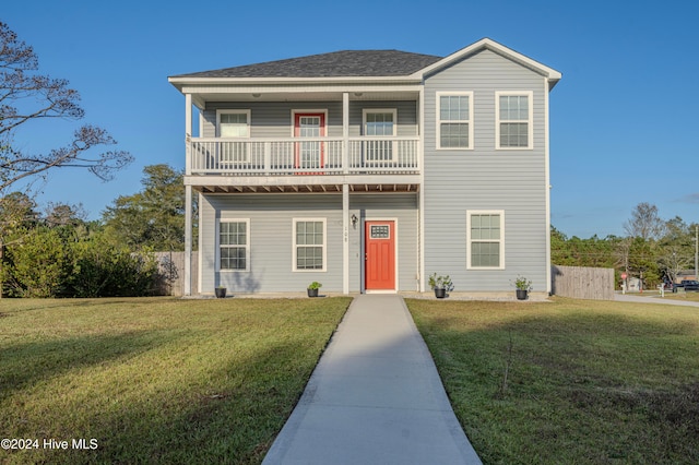 view of front property featuring a front yard and a balcony