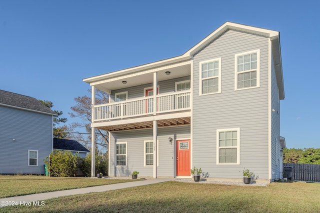 view of front of property featuring a front yard and a balcony