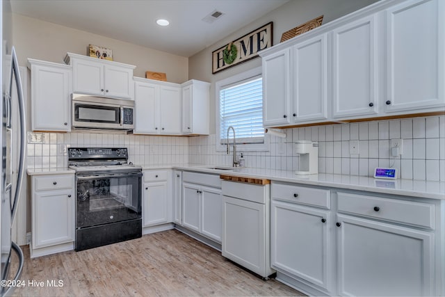 kitchen with white cabinets, light hardwood / wood-style floors, stainless steel appliances, and sink