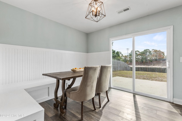 dining room with hardwood / wood-style flooring and a notable chandelier