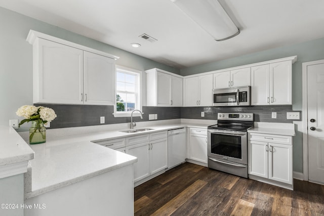 kitchen with appliances with stainless steel finishes, sink, white cabinets, dark hardwood / wood-style flooring, and backsplash