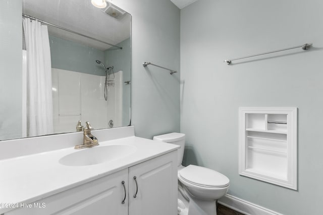 bathroom featuring a shower with curtain, vanity, and toilet