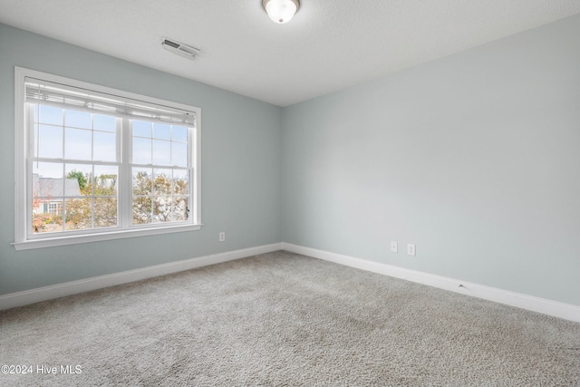 unfurnished room featuring carpet flooring and a textured ceiling