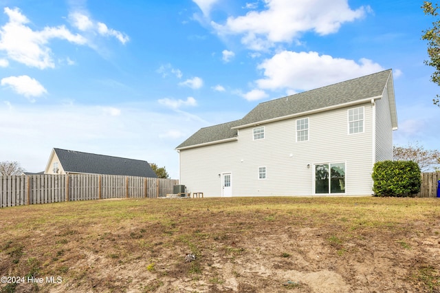 back of house featuring central AC and a yard