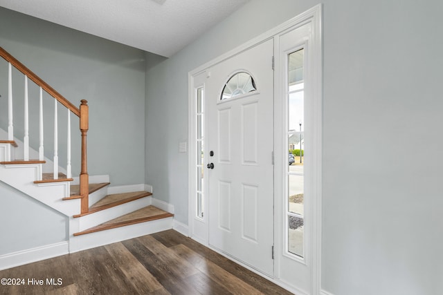 entrance foyer with dark wood-type flooring and a textured ceiling