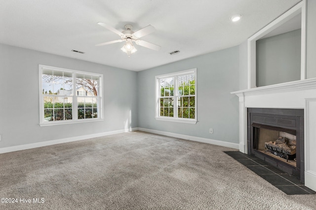 unfurnished living room featuring ceiling fan and dark colored carpet