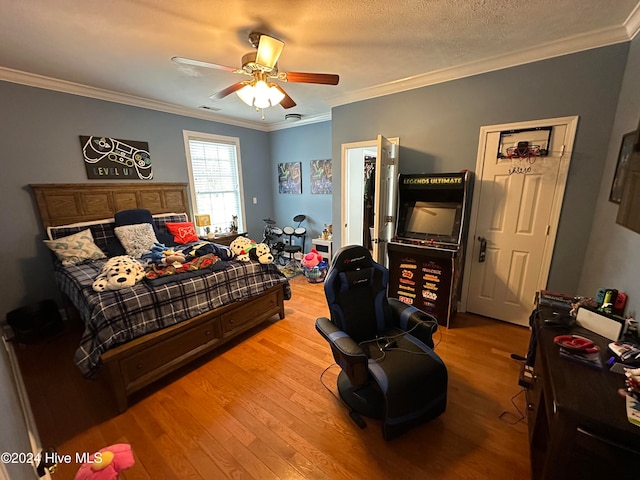 bedroom with ornamental molding, light hardwood / wood-style floors, a textured ceiling, and ceiling fan