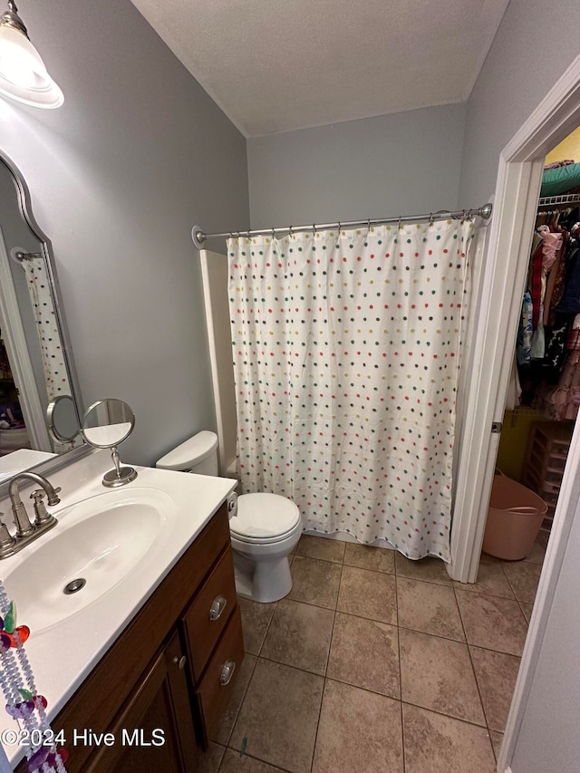 bathroom with tile patterned flooring, vanity, a textured ceiling, and a shower with shower curtain