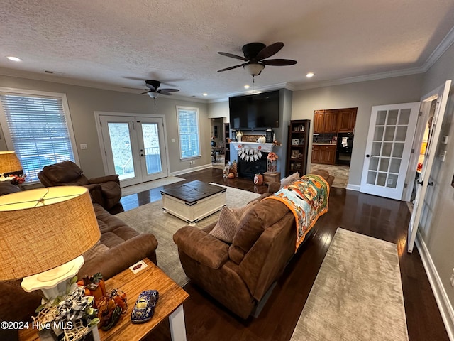 living room with french doors, ornamental molding, a textured ceiling, dark wood-type flooring, and ceiling fan