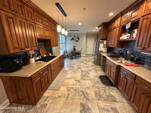 kitchen featuring light stone counters, decorative backsplash, black appliances, sink, and pendant lighting