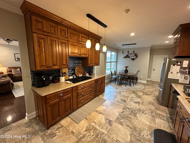 kitchen with light stone counters, stainless steel refrigerator, pendant lighting, decorative backsplash, and black gas stovetop