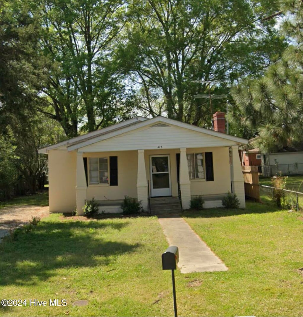 view of front of property with a porch and a front lawn