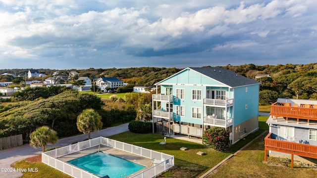 rear view of house featuring a fenced in pool