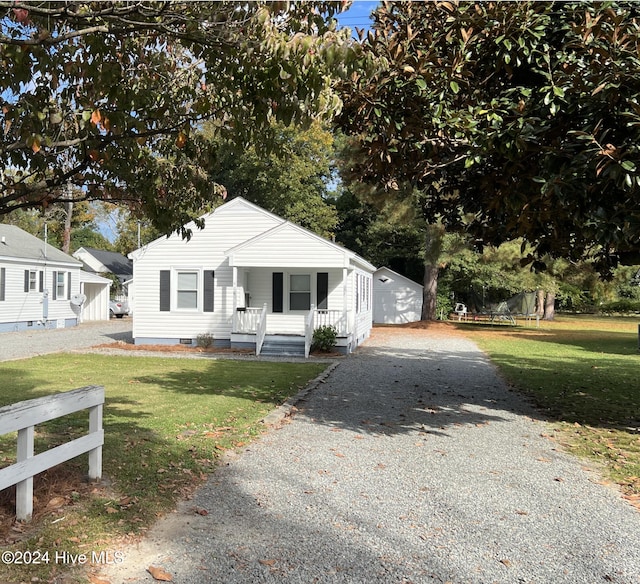 bungalow with a front yard and covered porch