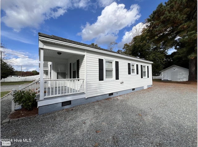 view of home's exterior featuring a porch and a shed