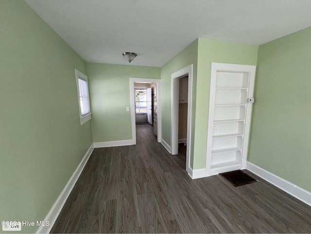 corridor with dark hardwood / wood-style flooring