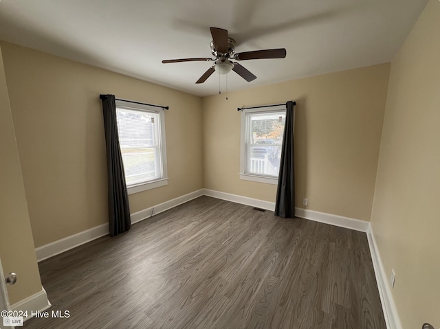 spare room featuring dark wood-type flooring and ceiling fan