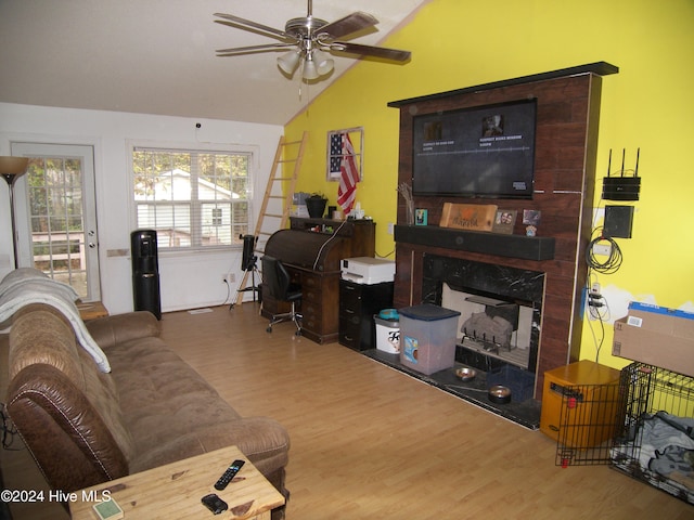 living room with a premium fireplace, wood-type flooring, ceiling fan, and vaulted ceiling