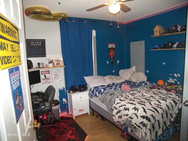 bedroom featuring wood-type flooring, a textured ceiling, and ceiling fan