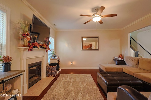 living room featuring ornamental molding, a fireplace, hardwood / wood-style flooring, and ceiling fan