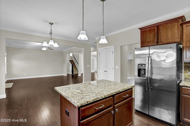 kitchen featuring crown molding, a kitchen island, appliances with stainless steel finishes, hanging light fixtures, and a kitchen breakfast bar