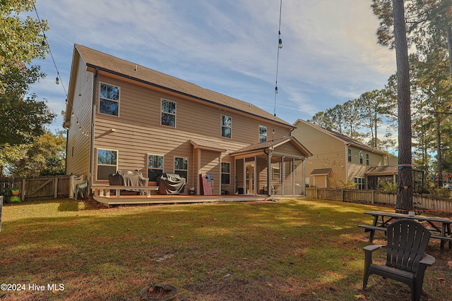 rear view of house with a yard and a deck