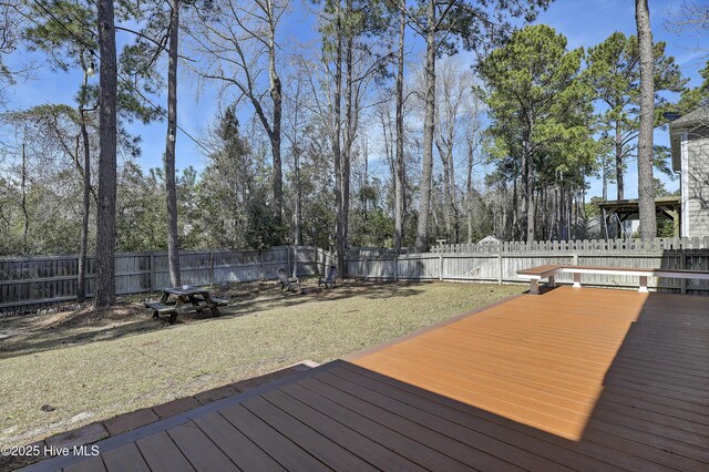 back of property featuring a wooden deck, a sunroom, and a yard