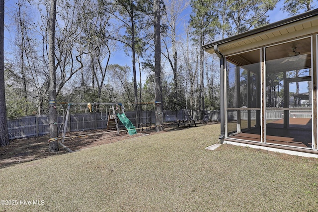 rear view of house featuring a sunroom and a yard