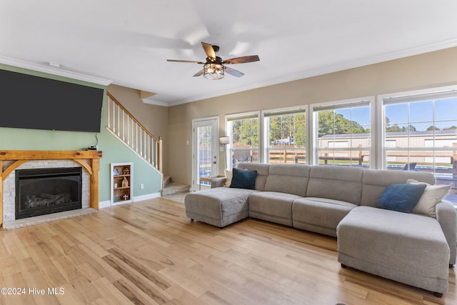 living room featuring light hardwood / wood-style flooring, ceiling fan, and crown molding