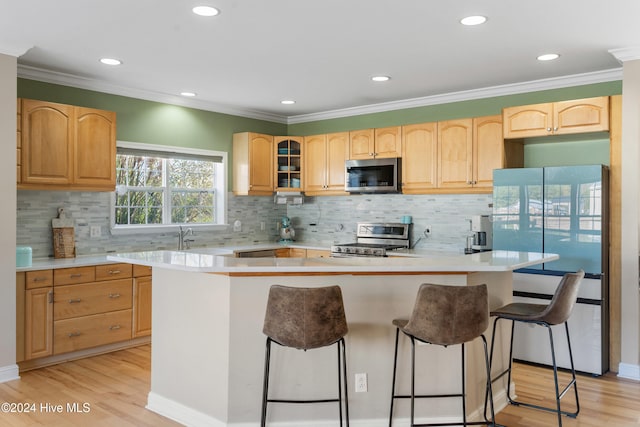 kitchen with stainless steel appliances, light hardwood / wood-style floors, a center island, a breakfast bar, and backsplash