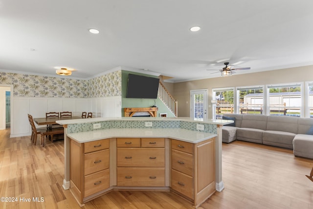 kitchen with ceiling fan, crown molding, light hardwood / wood-style flooring, and a kitchen island